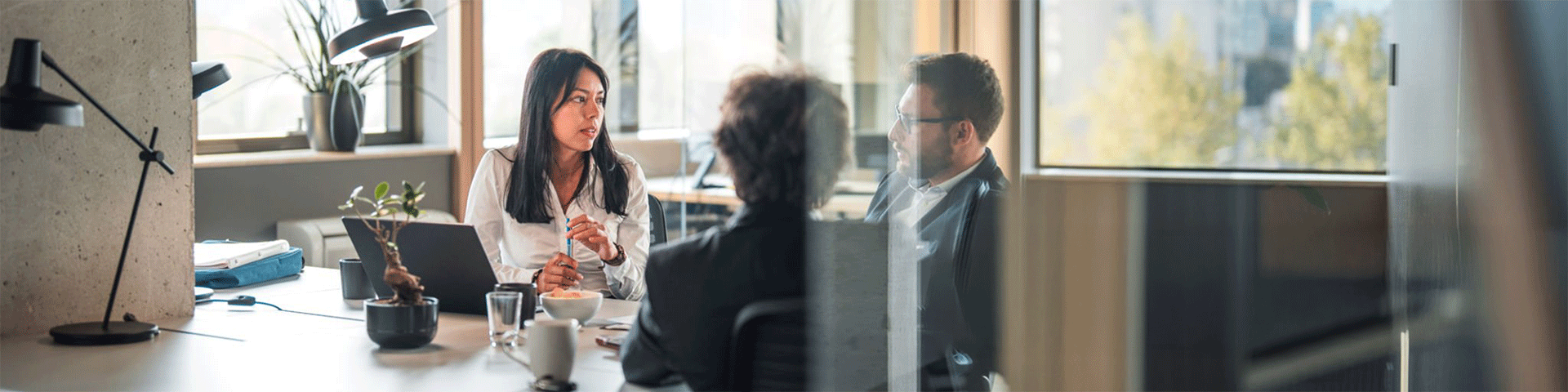 Three people having a discussion at a desk