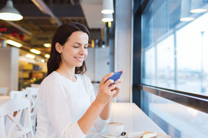 A lady smiling looking at mobile phone